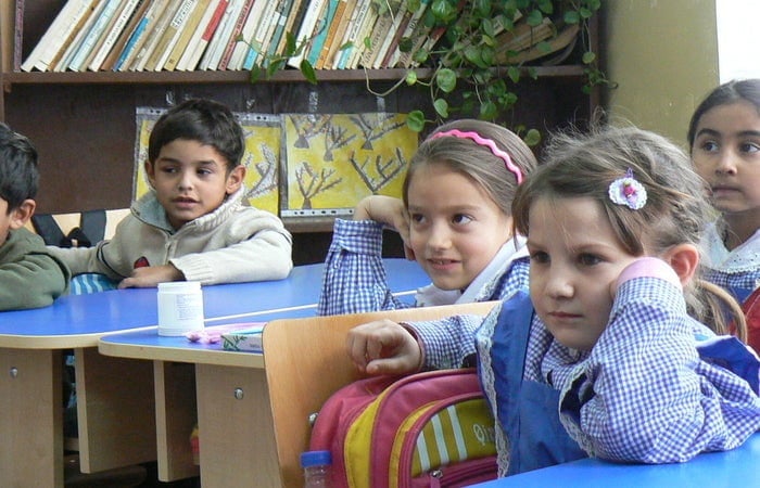 Photo of children sitting in desks in a classroom.