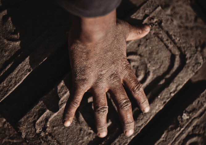 Photo of hand touching a carved stone.