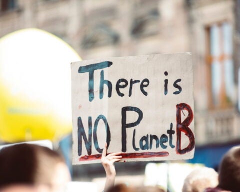 Image of person holding sign that reads, "There is no Planet B"