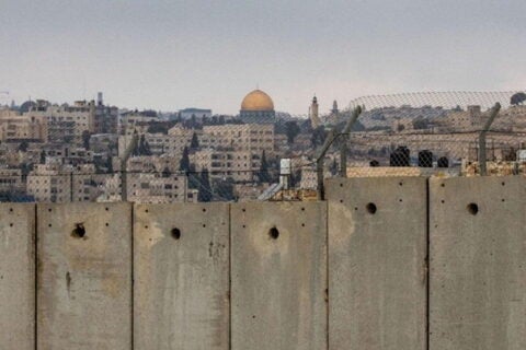 City of Jerusalem and Dome of Rock visible beyond concrete wall