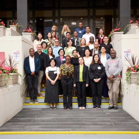 Group photo of 2024 FXB Landry Program participants standing at the steps in front of the Harvard School of Public Health.