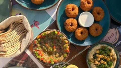 Various blue plates with food arranged on wooden table.