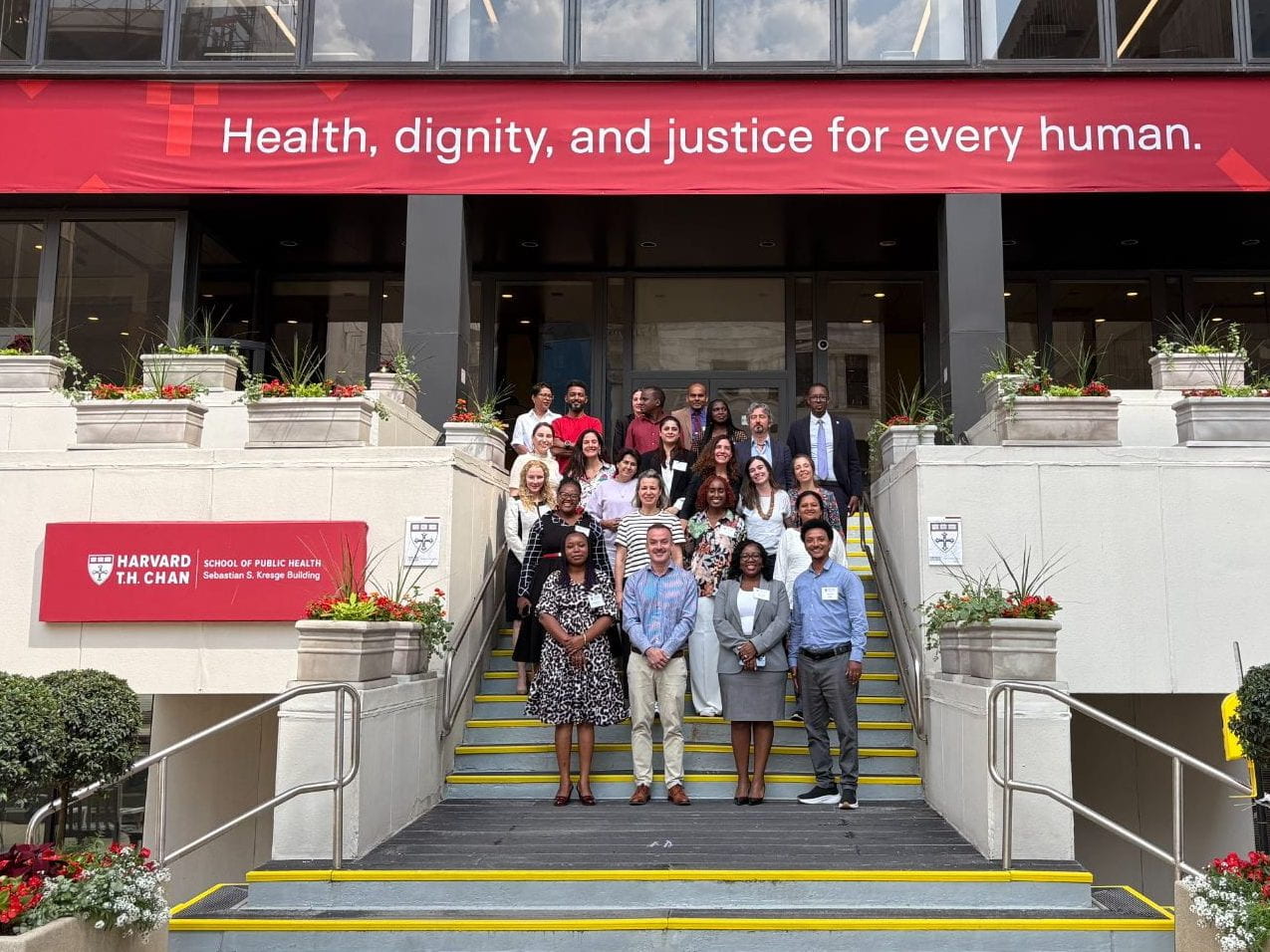 Photo of 2025 Landry professional training program cohort standing on steps in front of Harvard T.H. Chan School of Public Health.