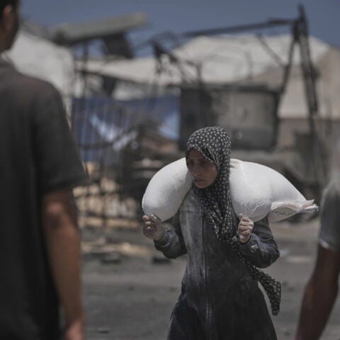 Palestinians carry sacks of flour unloaded from a humanitarian aid convoy that reached Gaza City from the northern Gaza Strip, Tuesday, July 22, 2025. AP Photo/Jehad Alshrafi.