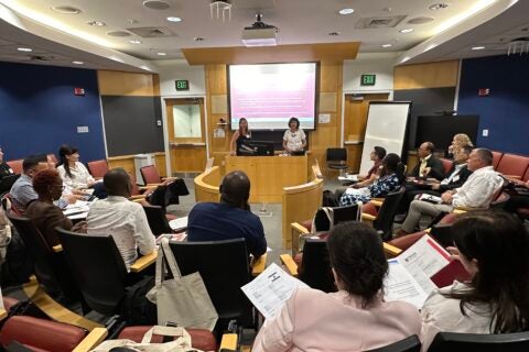 Group photo of 2024 Landry cohort during team presentations in auditorium-style classroom.