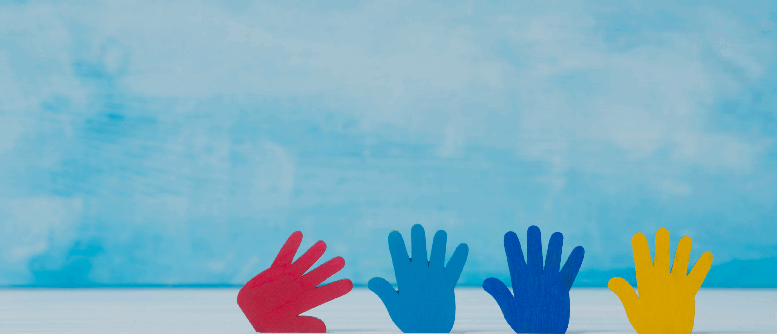 Graphic of blue background and row of hands in different colors along the bottom