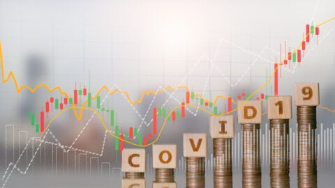 Word block COVID 19 on coins stack and financial stock market graph, Savings money and investment for business concept, Coronavirus impact global economy stock markets financial crisis concept.