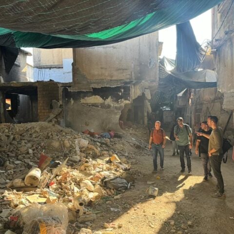 Photo of Dr. Bram Wispelwey and colleagues looking at rubble in the West Bank.