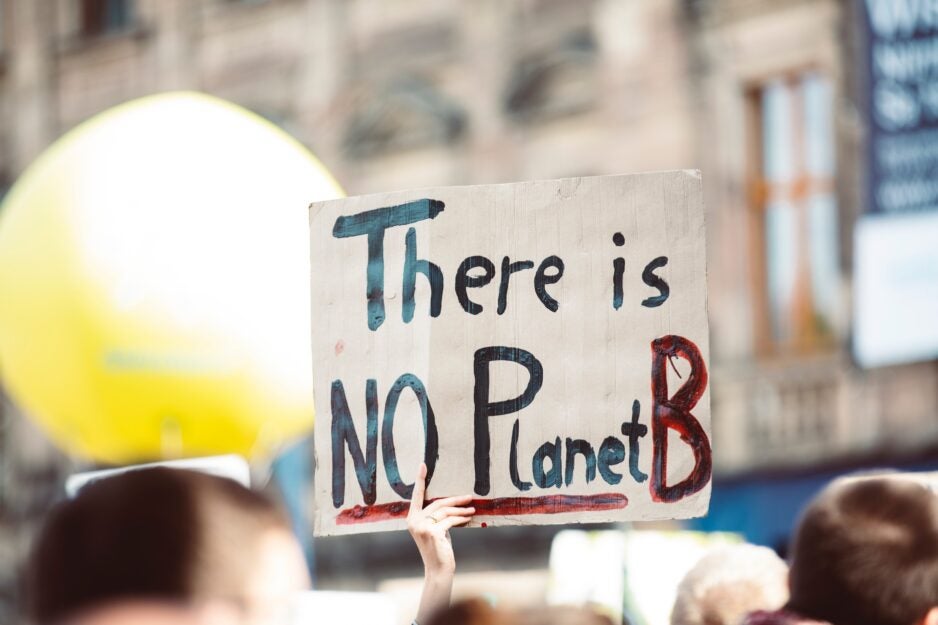 Image of person holding sign that reads, "There is no Planet B"