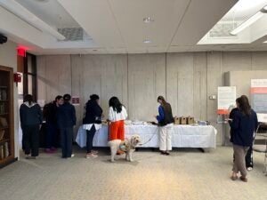 Attendees arriving and getting refreshments at he opening of the Exhibition “We Are Not Alone”: Legacies of Eugenics at Harvard's Countway Library