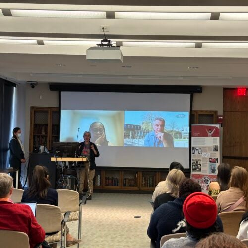 Nancy Krieger, PhD, addressing attendees of the opening of the exhibition “We Are Not Alone”: Legacies of Eugenics at Harvard's Countway Library. Evelynn Hammonds, PhD, and Marius Turda, PhD, are visible on Zoom on the screen behind her.