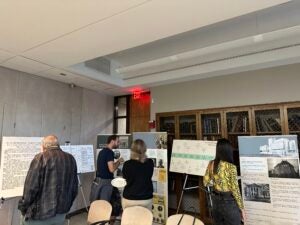 Attendees of the opening of the exhibition “We Are Not Alone”: Legacies of Eugenics at Harvard's Countway Library examining some of the exhibition posters and retractable banners.
