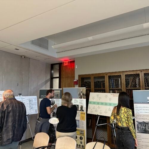 Attendees of the opening of the exhibition “We Are Not Alone”: Legacies of Eugenics at Harvard's Countway Library examining some of the exhibition posters and retractable banners.