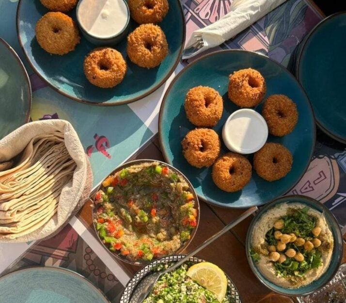 Various blue plates with food arranged on wooden table.